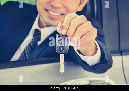 Homme d'affaires donnant une clé de voiture - effet de couleur de style vintage Banque D'Images
