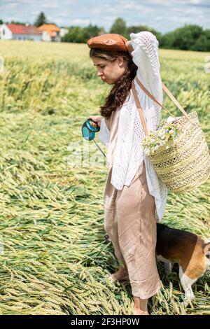 Fille blanche européenne sur terrain de blé en robe beige Banque D'Images
