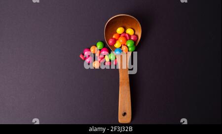ensemble de friandises multicolores avec une cuillère en bois Banque D'Images