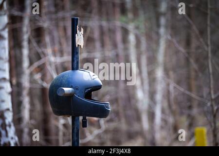 Une croix en bord de route avec un casque de moto commémorant la mort tragique d'un motocycliste. Fabriqué par temps nuageux, doux et doux. Banque D'Images