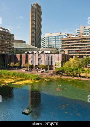 Vue sur le lac du Barbican Estate and Arts Centre, avec l'école Guildhall de musique et de théâtre en premier plan, avec la tour Cromwell dans le Banque D'Images