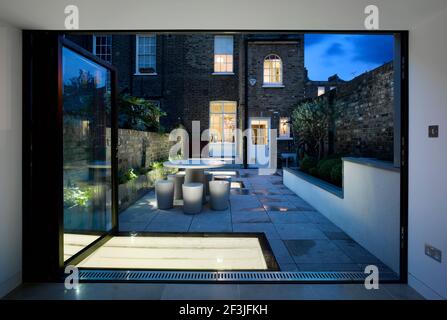 Photo du crépuscule du pavillon du jardin au nouveau niveau du jardin jusqu'à la maison géorgienne d'origine | architecte : Paul Archer Design | Banque D'Images