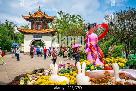 Kunming China , 3 octobre 2020 : fleurs de Chrysanthemum et statue au parc Grand View avec des gens devant un pavillon à Kunming Yunnan Chine Banque D'Images