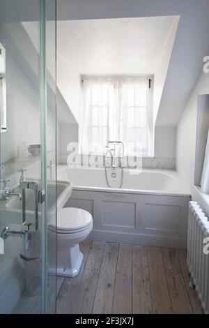 Salle de bains avec baignoire et douche dans la chambre sous les toits, Whitechapel, Londres Banque D'Images