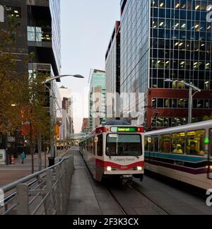 Deux trains légers passent l'un l'autre à l'heure de pointe, tôt le matin, dans le centre-ville de Calgary. Banque D'Images