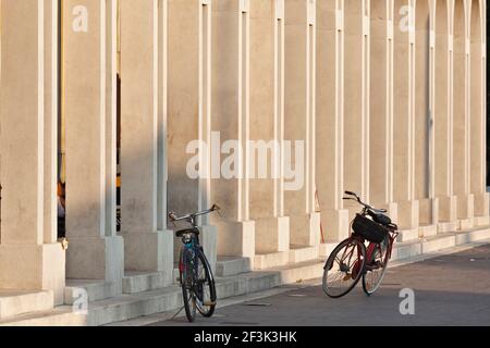 Les vélos garés devant un rationaliste arcade à la Piazza della Repubblica Tresigallo Emilia-Romagna Italie Banque D'Images