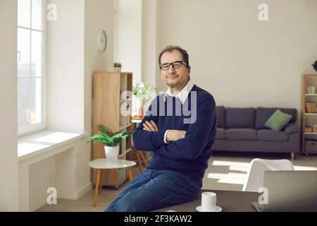 Portrait d'un homme d'affaires souriant et détendu d'âge moyen, vêti de vêtements et de lunettes décontractés. Banque D'Images