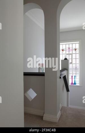 Ouvertures voûtées sur l'escalier avec fenêtre en vitrail en arrière-plan | AUCUN | Banque D'Images