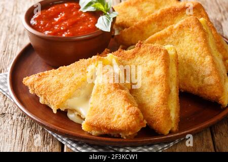 La mozzarella dans la carrozza est faite de pain tranché contenant la précieuse crémerie de la mozzarella dans la plaque sur la table. Horizontale Banque D'Images