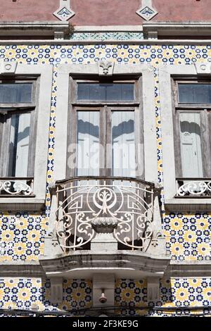 Des carreaux d'azulejos en céramique peinte entourent un balcon et une fenêtre sur la façade d'une maison à Ilhavo, Beira Litoral, Portugal Banque D'Images