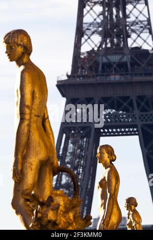 Des statues en bronze doré du Palais de Chaillot, avec la Tour Eiffel en arrière-plan, Paris, France. Banque D'Images
