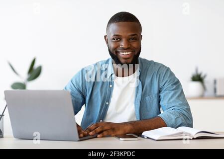 Portrait d'un entrepreneur afro-américain souriant qui pose sur le lieu de travail Au bureau Banque D'Images