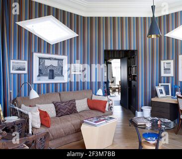 Canapé dans la chambre avec des murs à rayures verticales dans la maison résidentielle, Royaume-Uni Banque D'Images