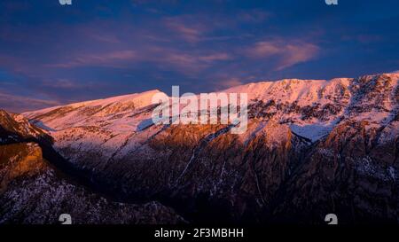 Vue aérienne de la face sud de Cadí au lever du soleil après une chute de neige hivernale (province de Barcelone, Catalogne, Espagne, Pyrénées) Banque D'Images