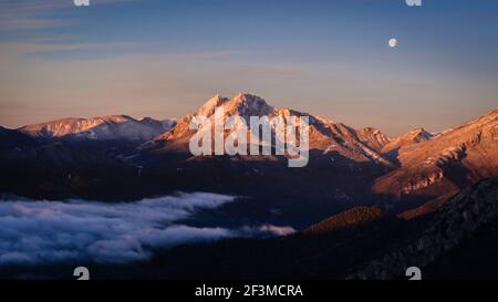 Lever de soleil à Pedraforca et Alt Berguedà avec pleine Lune, vue du point de vue de Coll de Pal (Berguedà, Catalogne, Espagne, Pyrénées) Banque D'Images