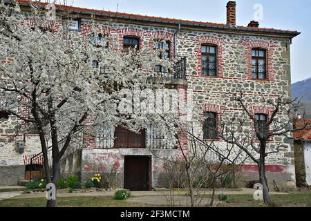 Façade traditionnelle de maison en pierre avec des fenêtres voûtées dans la campagne de Laimos, un village rural de l'ouest de la Macédoine dans le lac Prespa, Grèce. Banque D'Images