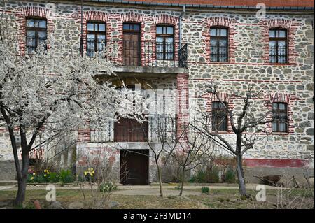 Façade traditionnelle de maison en pierre avec des fenêtres voûtées dans la campagne de Laimos, un village rural de l'ouest de la Macédoine dans le lac Prespa, Grèce. Banque D'Images