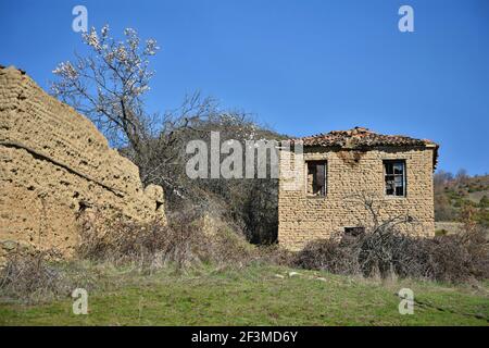 Paysage avec des maisons de boue traditionnelles abandonnées dans la campagne de Miliona, un village rural de l'ouest de la Macédoine dans le lac Prespa Grèce. Banque D'Images