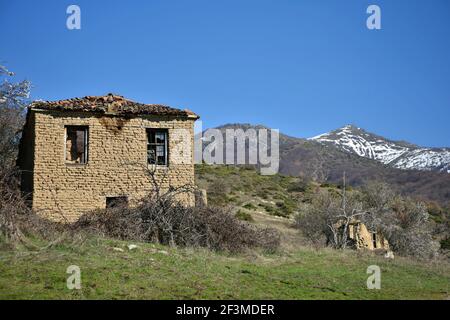 Paysage avec des maisons de boue traditionnelles abandonnées dans la campagne de Miliona, un village rural de l'ouest de la Macédoine dans le lac Prespa Grèce. Banque D'Images