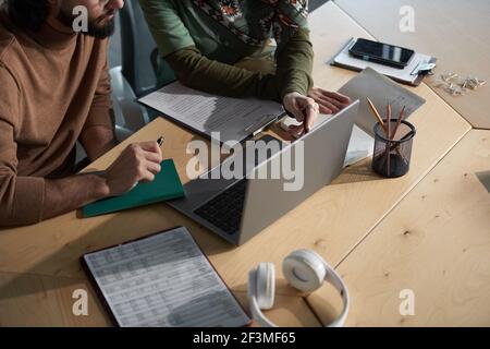 Gros plan des professionnels utilisant un ordinateur portable pour travailler sur le présentation en ligne en équipe au bureau Banque D'Images