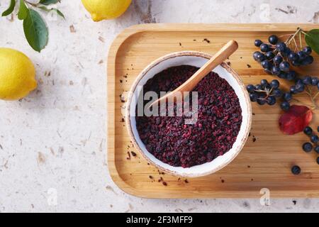 Thé aux baies Aronia dans un bol. Les baies d'aronia séchées sont couramment utilisées pour faire du thé riche en antioxydants. Banque D'Images