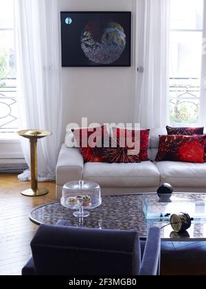 Table basse recouverte de verre et canapé avec coussins en français appartement Banque D'Images