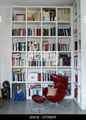 Arne Jacobsen fauteuil à œufs dans le coin de la chambre avec étagères Dans la maison française Banque D'Images