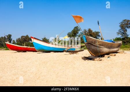 Bateaux de pêcheur solitaire sur la plage de Goa dans le nord de Goa, Inde Banque D'Images