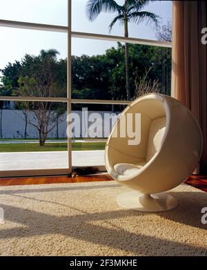 Chaise Eero Aarnio Globe devant la fenêtre avec vue sur le jardin, Brésil Banque D'Images