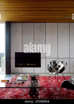 Table basse recouverte de verre devant la cheminée dans la salle de séjour Chambre dans la maison de Nouvelle-Zélande Banque D'Images