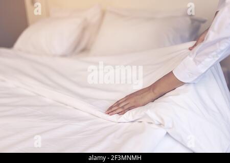 Femme de ménage asiatique dans la chambre d'hôtel, avec matelas à plateau-coussin Banque D'Images