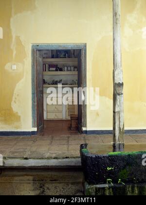 Piscine en face d'une porte en bois rustique ouverte avec vue sur la cuisine au-delà, Sri Lanka Banque D'Images