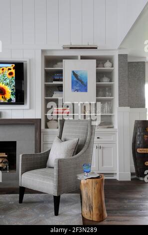 Fauteuil et armoire gris dans la salle de séjour, Cobble court Interiors, designer Robert Rizzo, New Canaan, Fairfield County, Connecticut, États-Unis Banque D'Images