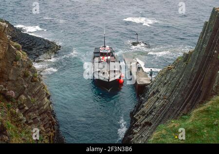 Bateau touristique à l'étape de l'atterrissage sur l'île de Staffa, en Écosse Banque D'Images