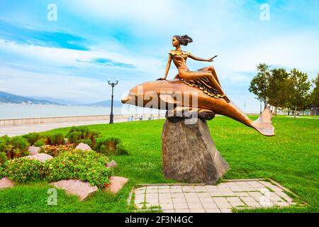 Novorossiysk, Russie - 02 octobre 2020 : une jeune fille sur une sculpture de dauphin dans la ville de Novorossiysk. Novorossiysk est le principal port de la mer Noire à Krasnodar Banque D'Images