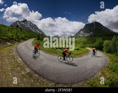 Femme cycliste sur la route privée à péage à travers Vengedalen, près d'Andalsnes, Norvège. Prise de vue multiple. Banque D'Images