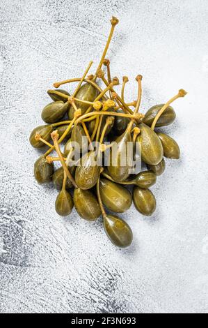 Câpres marinés sur une table de cuisine. Arrière-plan blanc. Vue de dessus Banque D'Images