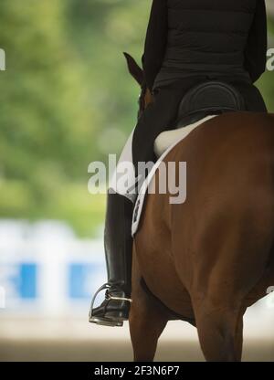 Cavalier de dressage équestre dans le siège de dressage approprié montrant le grand noir bottes de dressage beige jodhpurs anglais cuir dressage selle blanc selle bloc Banque D'Images