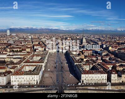 Vue aérienne du centre-ville de Turin, en Italie, par temps ensoleillé, avec Mole Antonelliana et les Alpes en arrière-plan. Banque D'Images