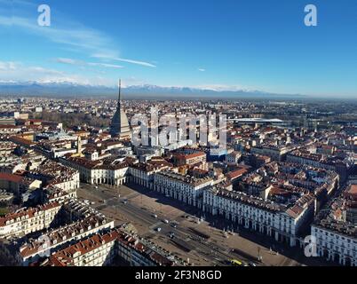 Vue aérienne du centre-ville de Turin, en Italie, par temps ensoleillé, avec Mole Antonelliana et les Alpes en arrière-plan. Banque D'Images