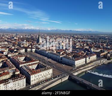 Vue aérienne du centre-ville de Turin, en Italie, par temps ensoleillé, avec Mole Antonelliana et les Alpes en arrière-plan. Banque D'Images