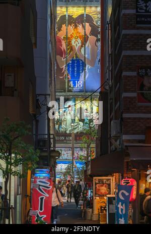 tokyo, japon - avril 29 2018 : affiches publicitaires d'anime japonais entre les gratte-ciels d'akihabara avec restaurant de nouilles ramen illuminé Banque D'Images