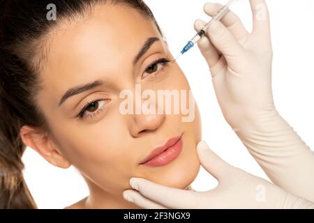 Portrait d'une jeune belle femme sur un visage de remplissage procédure d'injection sur fond blanc Banque D'Images