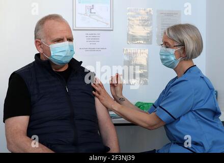 Gillian Bruce, coordinatrice de l'équipe de vaccination de NHS Forth Valley, donne un vaccin à Ian Love de Dunipace, sur le campus de Stirling du Forth Valley College, alors que le gouvernement écossais annonce avoir vacciné plus de deux millions de personnes, alors que les mesures de confinement pour l'Écosse continentale se poursuivent. Date de la photo: Mercredi 17 mars 2021. Banque D'Images
