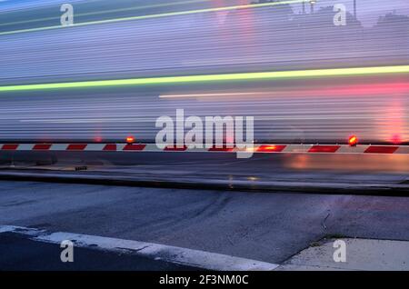 Elgin, Illinois, États-Unis. Un train de banlieue Metra en mouvement présente un aspect fantomatique car il strie par un passage à niveau protégé. Banque D'Images