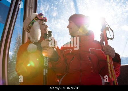 des amis joyeux sur les remontées mécaniques de ski monter sur la montagne enneigée Banque D'Images