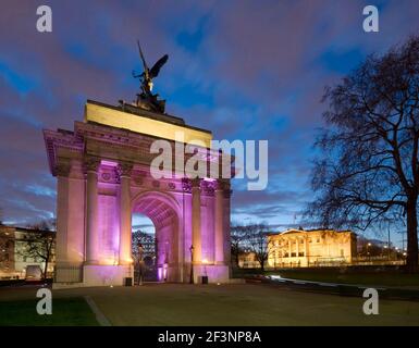 THE WELLINGTON ARCH, Hyde Park Corner, Londres. Vue sur l'arche illuminée et Apsley House au loin. Banque D'Images