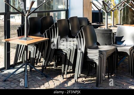 Chaises et tables empilées dans un restaurant fermé dû à un virus corona Banque D'Images