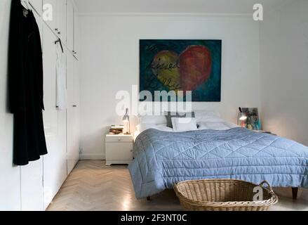 Un style parfait dans tous les détails. Une chambre avec couvre-lit bleu, une peinture au-dessus du lit et un lit à pied. Banque D'Images