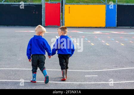 Les élèves du primaire jouent dans un terrain de jeux dans une pause entre les cours en classe. Banque D'Images